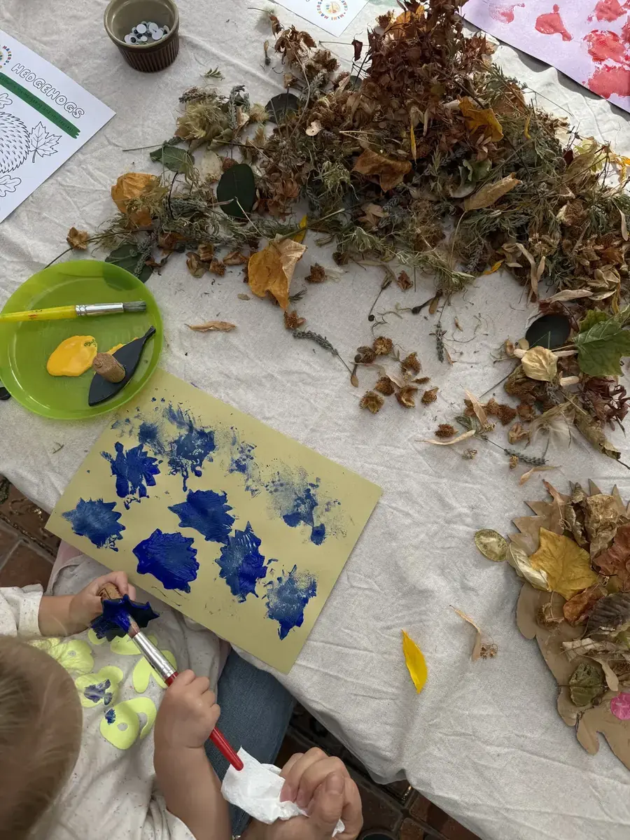 A child printing blue shapes onto yellow paper